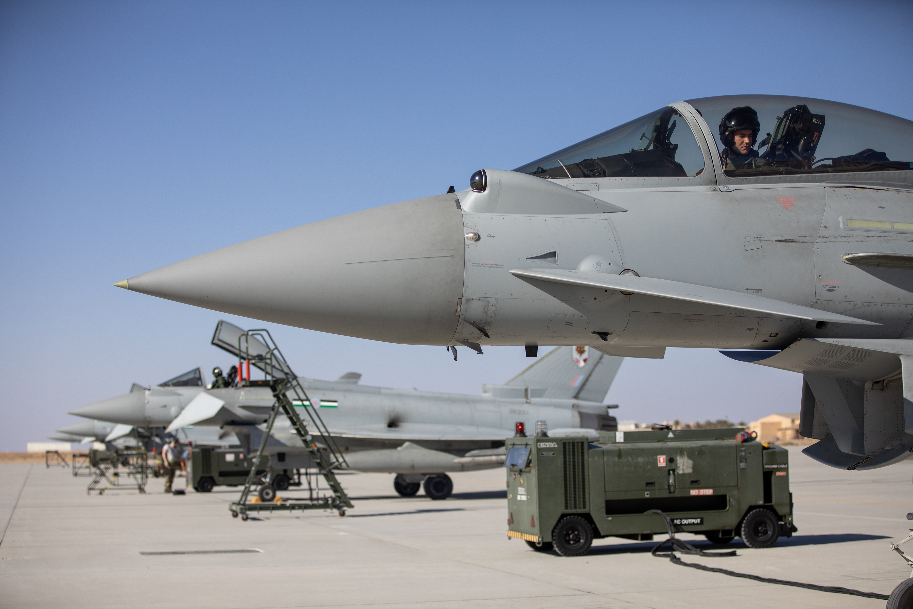 Image shows RAF personnel sitting in the cockpit of Typhoons on the airfield.